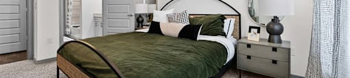 A bedroom with a bed, nightstand, and a ceiling fan.