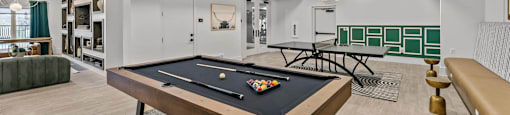 A pool table is in the middle of a room with a green ceiling.