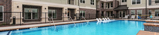 A swimming pool in front of apartment buildings.