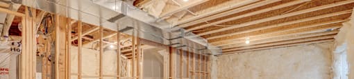 A room under construction with wooden framing and insulation on the walls.