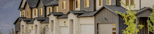 A row of houses with a mountain in the background at Mt. Rainier townhomes for rent in Herriman, Utah.