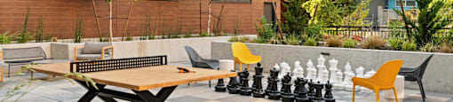 A chess set is set up on a table outside.