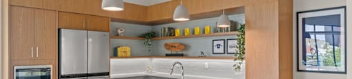 A modern kitchen with a white countertop and orange chairs.