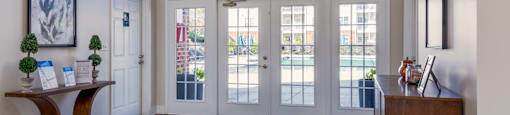 the inside of the clubhouse with large arched window and a wooden table.