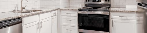 A kitchen with white cabinets and stainless steel appliances.