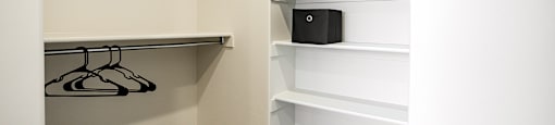 A white closet with a black box on the shelf.