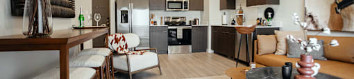 A modern kitchen with a dining area and a living room.