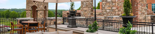 a terrace with couches and umbrellas and a tower