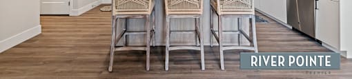 A kitchen with a dining table and chairs in the middle.