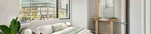 a bedroom with a white bed and a large window