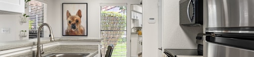 A kitchen with a stainless steel refrigerator and black appliances.