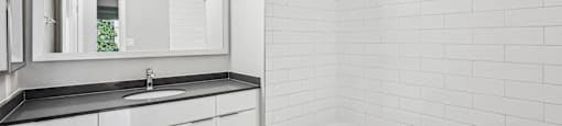 A white bathroom with upgraded fixtures and tile surround