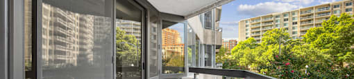 a long balcony with glass doors and a city in the background