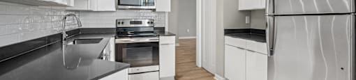 a modern kitchen with stainless steel appliances and white cabinets