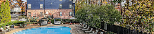 A large blue building with a pool in front.
