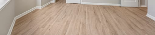 A large beroom with luxury plank flooring and spacious closet