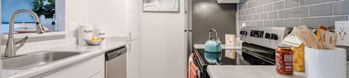 A modern kitchen with white cabinets and a grey countertop.