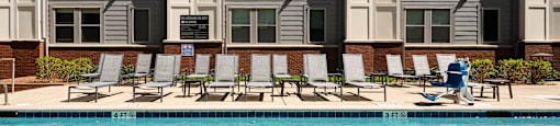 a person walking by a swimming pool in front of an apartment building