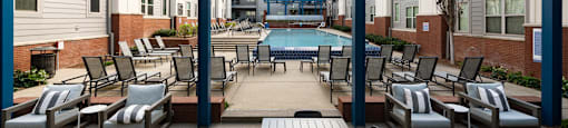 a patio with tables and chairs and a pool in the middle of an apartment building