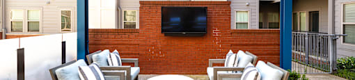 a lounge area with chairs and a table and a television