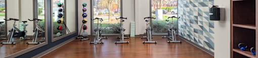a fitness room with exercise equipment and windows