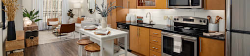 a kitchen and dining room with wooden cabinets and stainless steel appliances
