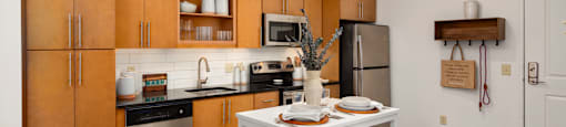 a kitchen with wooden cabinets and a white table with stools