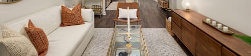 a living room with a white couch and a glass coffee table