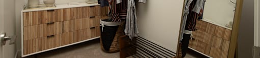 a walk in closet with a mirror and clothes rack