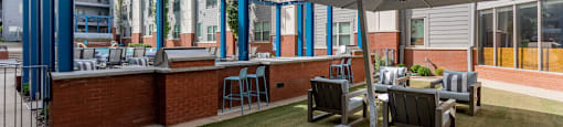 a patio with tables and chairs and a bar in front of an apartment building