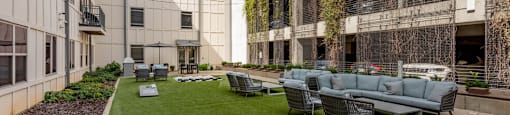 a courtyard with a couch and chairs in front of some buildings