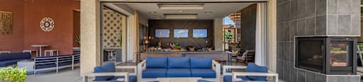 a lobby with blue couches and chairs and a fireplace