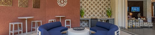 a lobby with two blue couches and a white coffee table