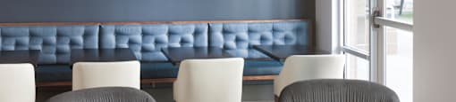 a living room with two gray chairs and a blue couch in the background and a coffee table