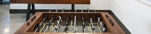 a foosball table sits in the center of a room with a tv on the wall