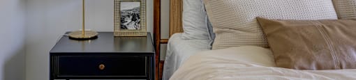A bed with a white comforter and a brown pillow is in the foreground of the image.