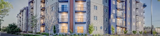 A modern apartment building with a mix of stone and panel exterior.