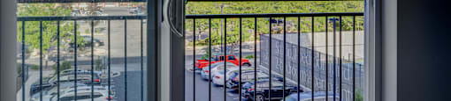 A view from a window looking out to a parking lot and mountains.