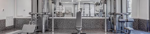 a gym with equipment and mirrors in a building