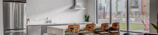 A modern kitchen with a bar area and a view of the backyard.