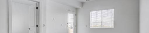 an empty living room with white walls and wood floors