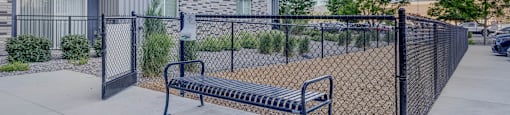 A black fence surrounds a concrete bench.