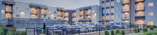 A modern building with a parking lot in front of it.