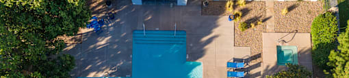 an aerial view of a swimming pool with a blue cross on it