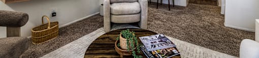 A living room with a grey chair and a brown coffee table.