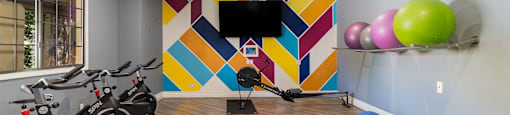 the gym with exercise bikes and a tv on the wall