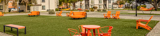 an outdoor seating area with tables and chairs on the grass