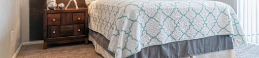 A bedroom with a bed and a wooden headboard at Westmount at Urban Trails, Mesa, 85202