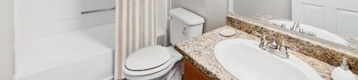 A white bathroom with a toilet, sink, and shower.
