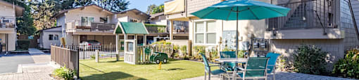 play area with a swing set and a playhouse